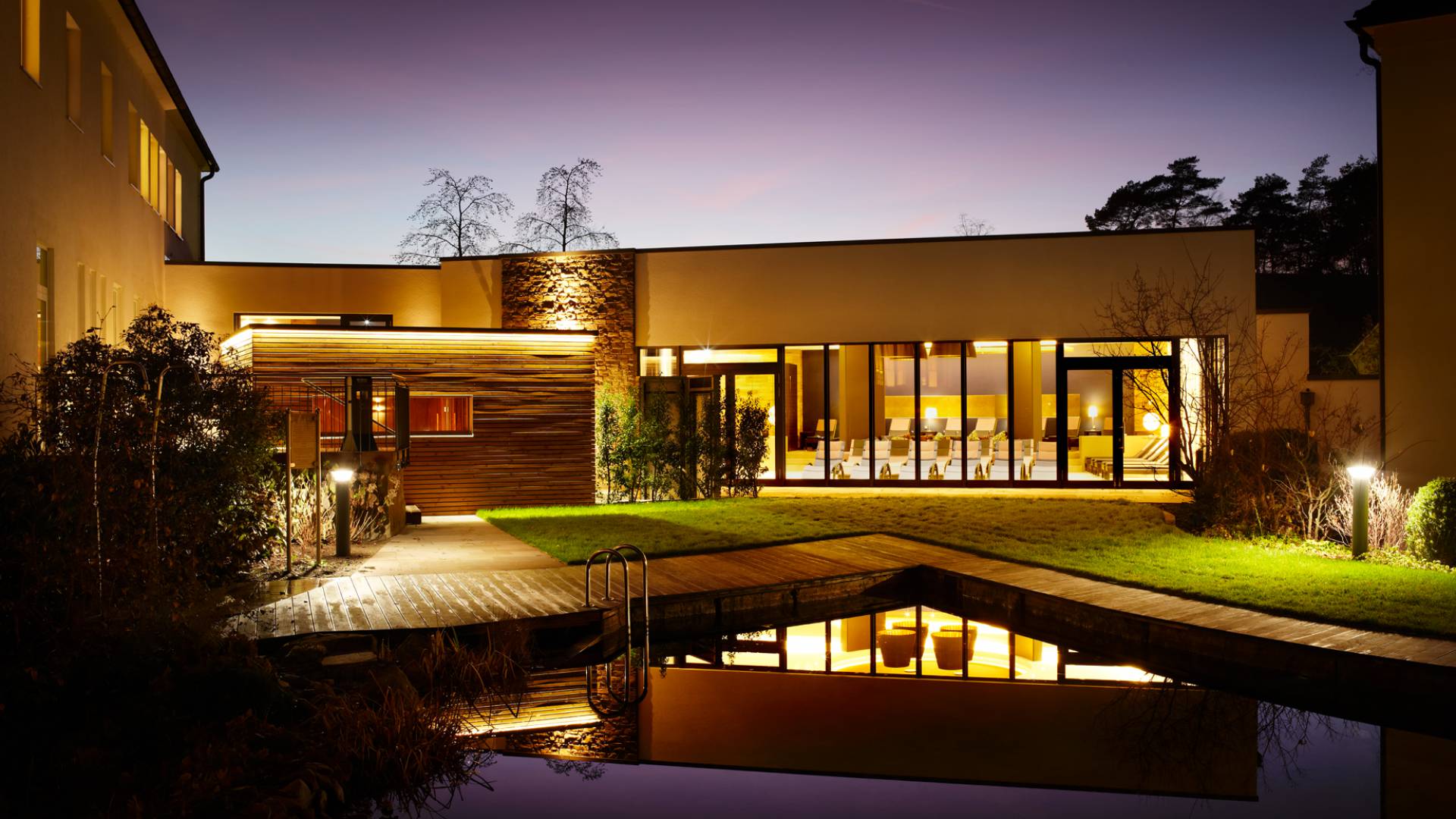 Beleuchteter Außenbereich mit Pool und Grünanlage Park Hotel Bad Lippspringe